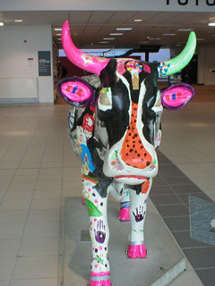 Head on view of a cow painted in black and bright colours