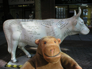 Mr Monkey in front of a cow covered with cow jokes