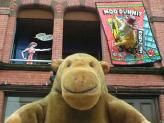 Mr Monkey with a woman shooting down a pulp magazine cow in the windows above him