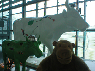Mr Monkey with a large white cow and a small green cow, connected by flashing lights