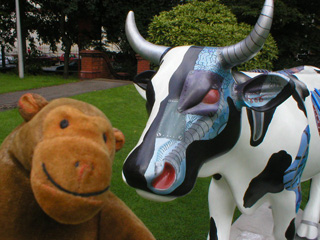 Mr Monkey in front of a cow with bionic parts