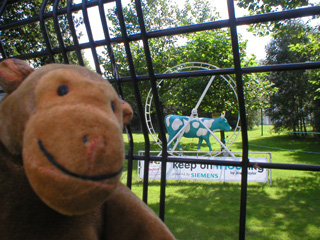 Mr Monkey in front of a cow in a big wheel