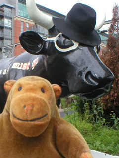Mr Monkey examining the glasses and trilby of the noir cow