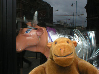 Mr Monkey with a silver suited cow behind him