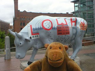 Mr Monkey with a cow which has a Lowry scene and the word LOWRY painted on it