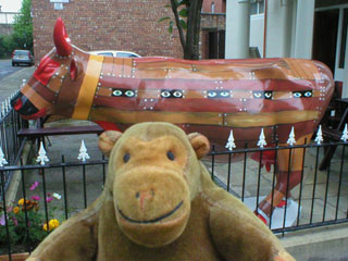Mr Monkey with a cow painted as a wooden structure with warriors' eyes visible through slits in the side