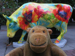 Mr Monkey with a cow decorated with red and orange poppies