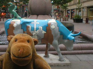 Mr Monkey with a cow decorated with an abstract Liverpool skyline