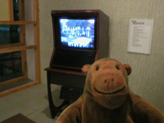 Mr Monkey watching the Coronation on a TV set from the 1950s