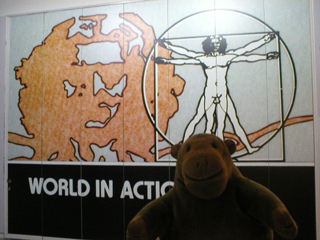 Mr Monkey standing in front of the World in Action logo