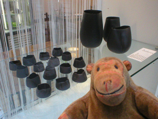 Mr Monkey looking at vessels made by Sara Flynn