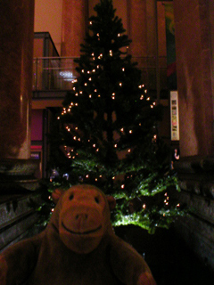 Mr Monkey examining one of the Royal Exchange's Christmas trees