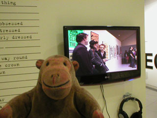 Mr Monkey watching a video showing the opening of the PUNK exhibition