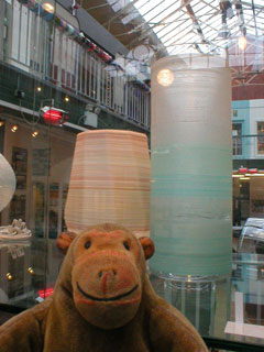 Mr Monkey looking at a vase and a table lamp by Jenny Bland