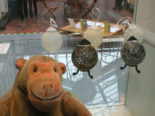 Mr Monkey looking at hanging decorations by Jenny Bland