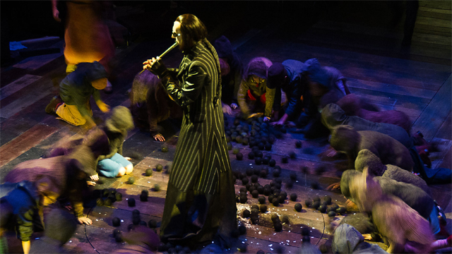 The Pied Piper (Michael Mears) preparing to remove the rats from Hamelin (Royal Exchange Theatre production photo)