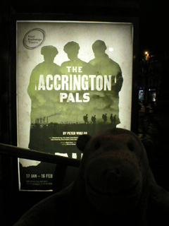 Mr Monkey looking at the The Accrington Pals poster outside the theatre