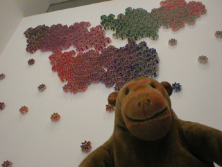 Mr Monkey looking at a wall of Jennifer Yang's Kaleidoscope pieces