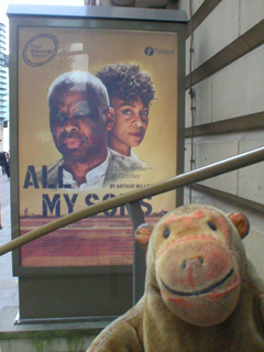 Mr Monkey looking at the All My Sons poster outside the theatre