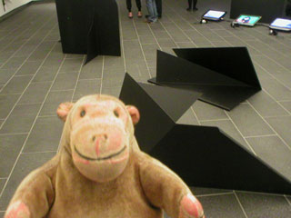 Mr Monkey looking at the floor-based parts of Gravestone for Rumour Monger by Liu Ding