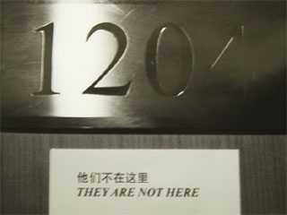 The room number and They Are Not here label on the hotel door