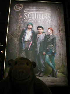 Mr Monkey looking at the Scuttlers poster