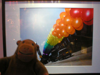 Mr Monkey looking at a photo of brightly coloured balloons