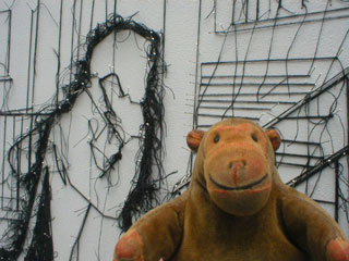 Mr Monkey looking at a man on a mobile phone in one of Debbie Smyth's street scenes
