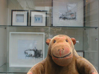 Mr Monkey looking at a cabinet of smaller pieces by Debbie Smyth