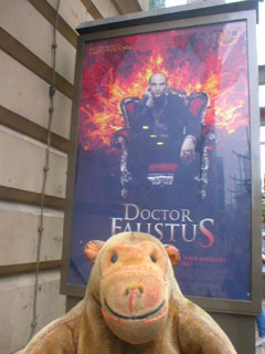 Mr Monkey looking at the Faustus poster outside the theatre