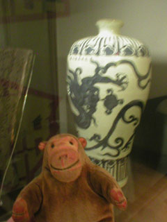Mr Monkey looking at a blue and white Ming vase