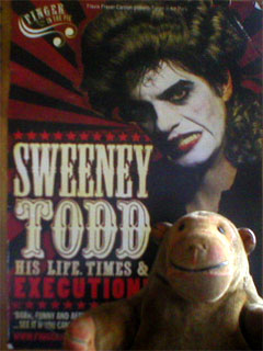 Mr Monkey standing in front of the Sweeney Todd programme