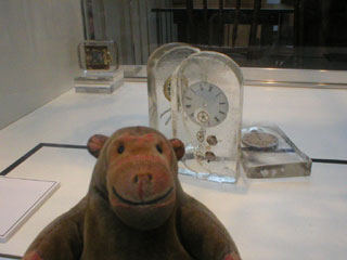 Mr Monkey looking at resin clock sculptures by Nadia Peters