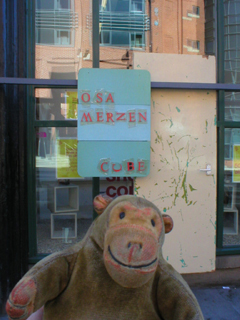 Mr Monkey looking at the osa/MERZEN/ door in the window of the CUBE
