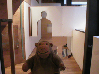 Mr Monkey looking at the human silhouette cut-out on the way to the RIBA shop