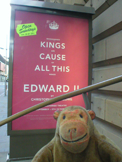 Mr Monkey looking at the Kings Cause All This poster outside the theatre