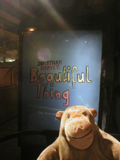 Mr Monkey looking at the Beautiful Thing poster outside the theatre