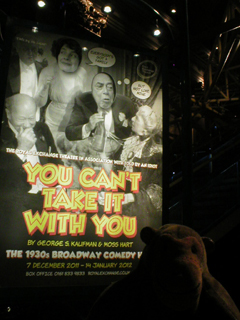 Mr Monkey looking at the You Can't Take It With You poster inside the theatre