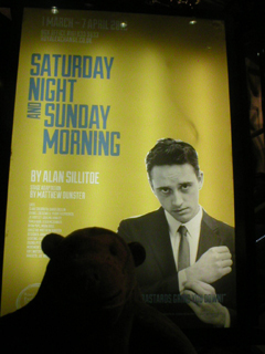 Mr Monkey looking at the Saturday Night and Sunday Morning poster inside the theatre