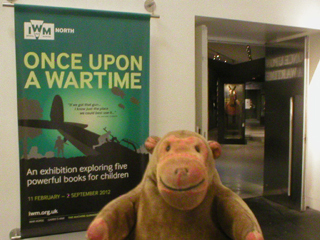 Mr Monkey looking at the poster outside the Once Upon A Wartime exhibition