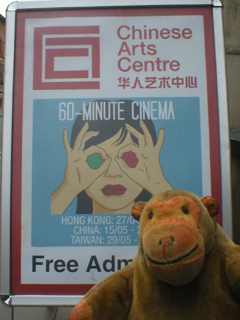 Mr Monkey looking at the 60-Minute Cinema poster outside the CAC