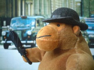 Mr Monkey waving his rolled umbrella at a roadful of London taxis