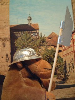 Mr Monkey wearing his kettle hat in a medieval town square