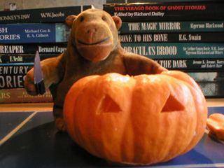 Mr Monkey standing beside a two-eyed pumpkin