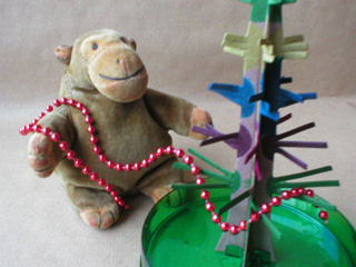 Mr Monkey draping baubles onto his tree