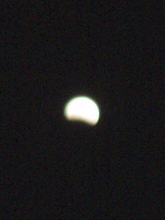 The moon at ten to ten, with a larger shadow at the bottom