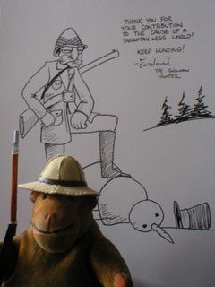 Mr Monkey standing in front of a signed drawing of the Snowman Hunter