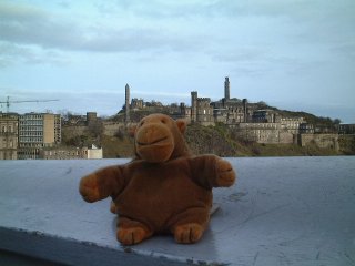 Mr Monkey on North Bridge, with Carlton Hill behind him