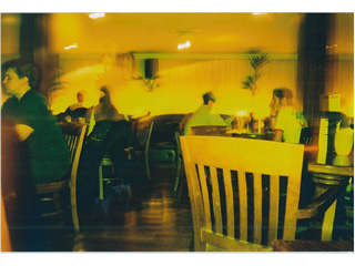 A slightly blurry picture of a restaurant, taken with a yellow flash