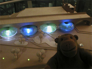 Mr Monkey looking at Claire Magee's model of a Museum of Movement